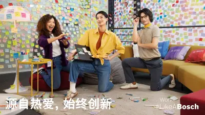 一个多元化的员工团队在一间贴满便利贴的会议室里摆姿势拍照，大家显得非常高兴。 
