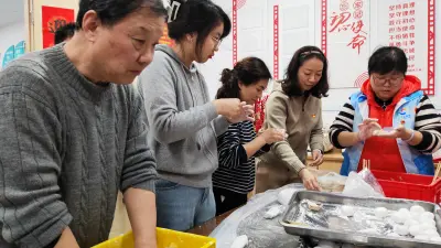 图：博世志愿者和长宁区刘三居委会辖区内的老人一起包汤圆、包饺子。